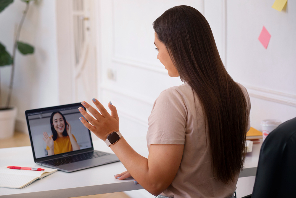 O femeie discută la laptop într-o sesiune de coaching online.